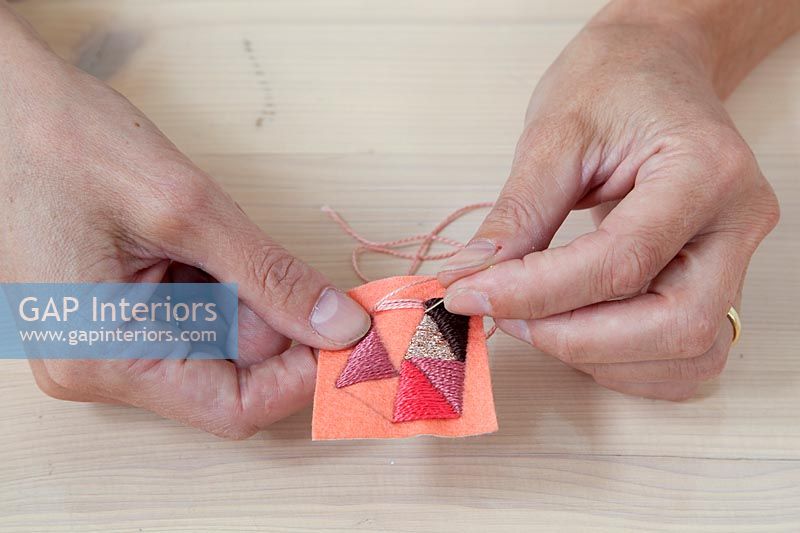 Woman sewing shapes into material 