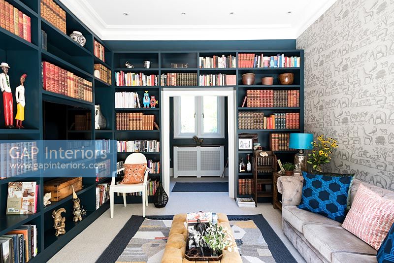 Dark blue painted wall to wall bookcases 