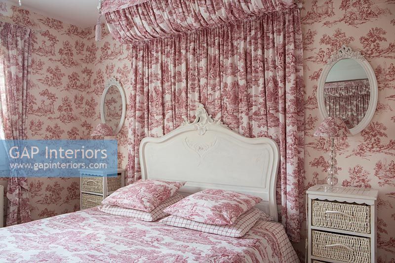Pink and white bedroom with fabric canopy and wallpaper 