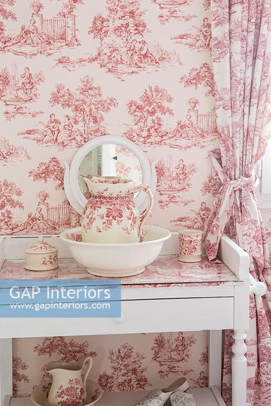 Pink and white vintage ceramics with matching wallpaper and curtains 