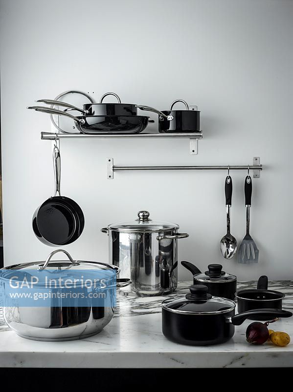 Black and chrome pots and pans in kitchen 