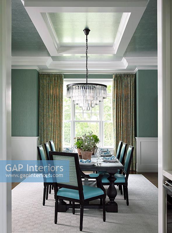 Modern dining room with turquoise chairs and elegant chandelier 