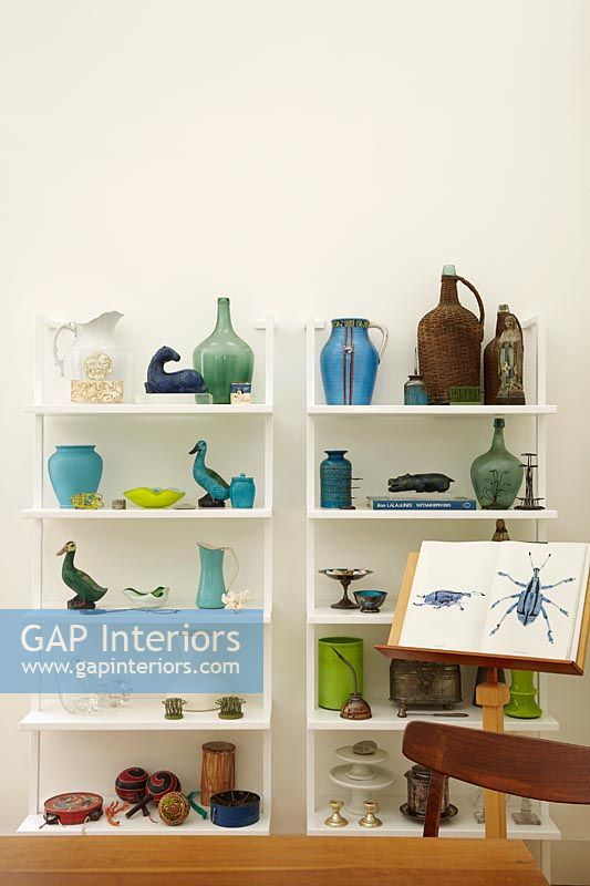 Two shelving units filled with glassware and ceramics on display 