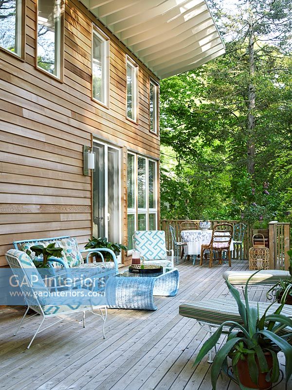 Furniture on decking of wooden house in woodland 