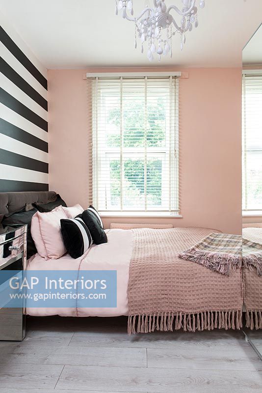 Pink bedroom with black and white striped wall 