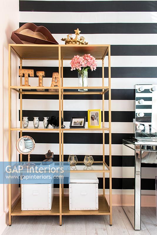 Shelf unit with black and white striped wall  