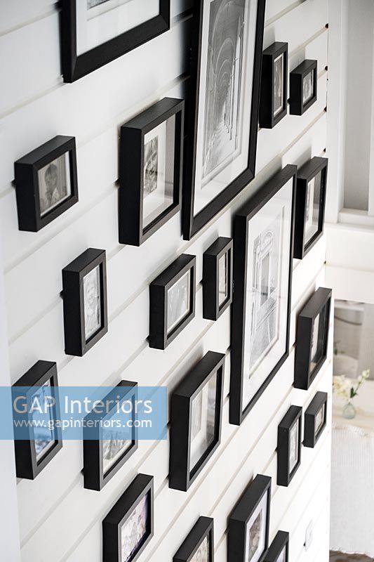 Display of framed pictures on staircase wall 