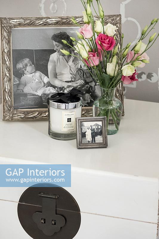 Family photographs and flowers on bedside table 