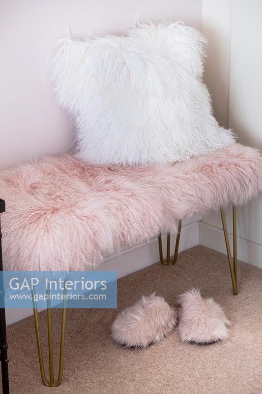 Furry slippers, seat and cushion in modern bedroom 