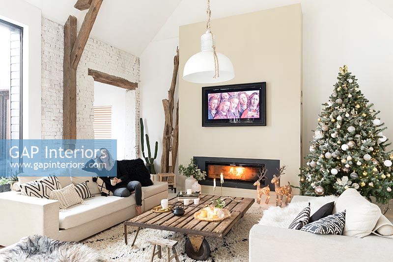 Woman relaxing in modern country living room at Christmas time 