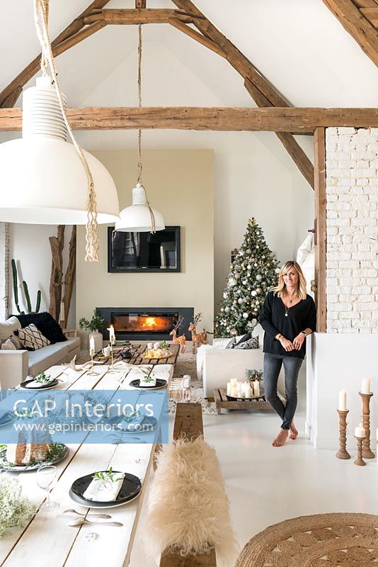 Woman in open plan living and dining room decorated for Christmas 