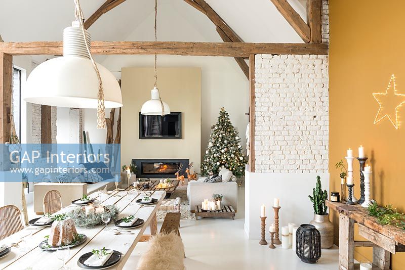Open plan modern country living space with dining table set for Christmas 