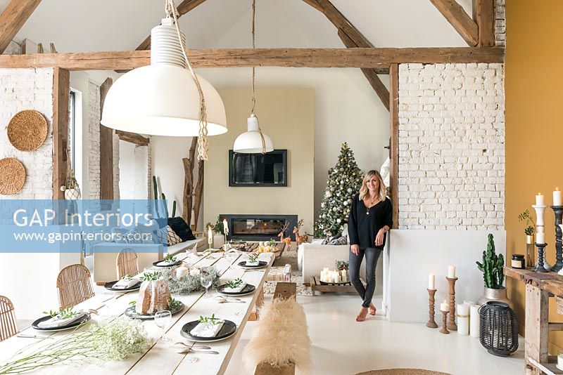 Woman in open plan living space decorated for Christmas 