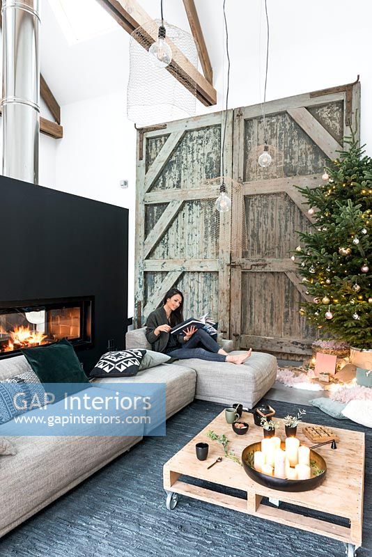 Woman relaxing in living room decorated for Christmas 
