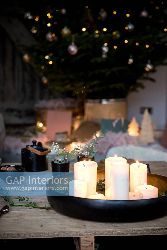 Circular tray of lit candles and Christmas tree 