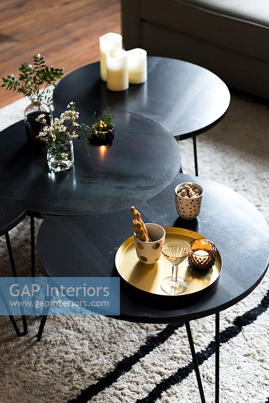 Modern black coffee tables with tea and biscuits and candles 