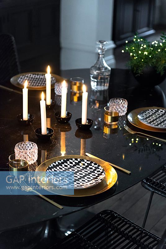 Gold crockery and cutlery on black dining table 