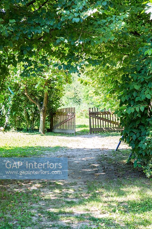 Country driveway with open gate