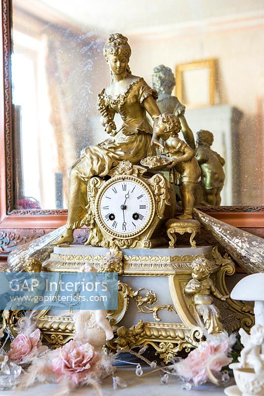 Ornate gold clock on mantelpiece 