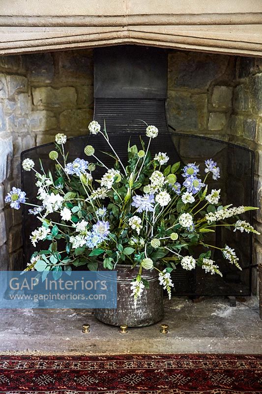 Flower arrangement in large fireplace 