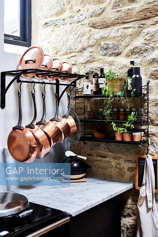 Copper pots on storage rack in modern kitchen 
