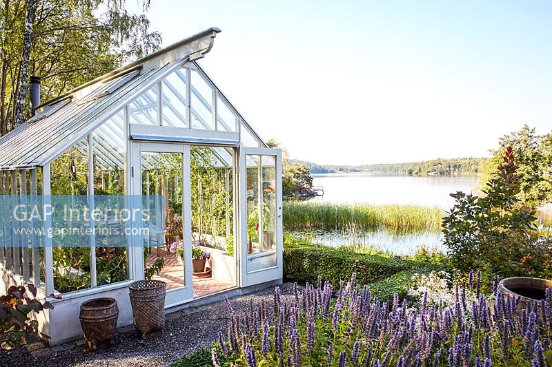 Greenhouse in garden overlooking lake 