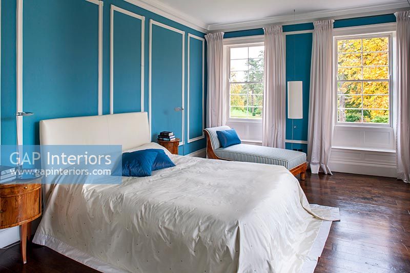 Classic bedroom with blue painted paneled walls 
