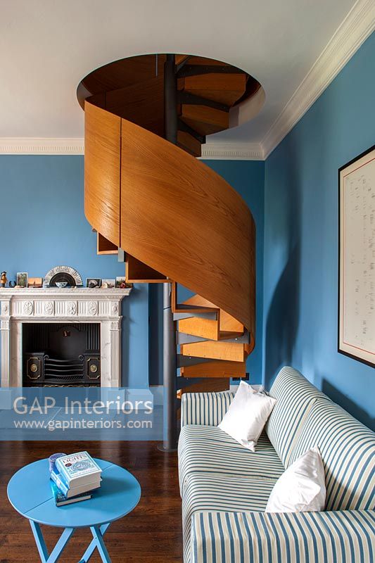 Blue and white room with wooden and steel spiral staircase 