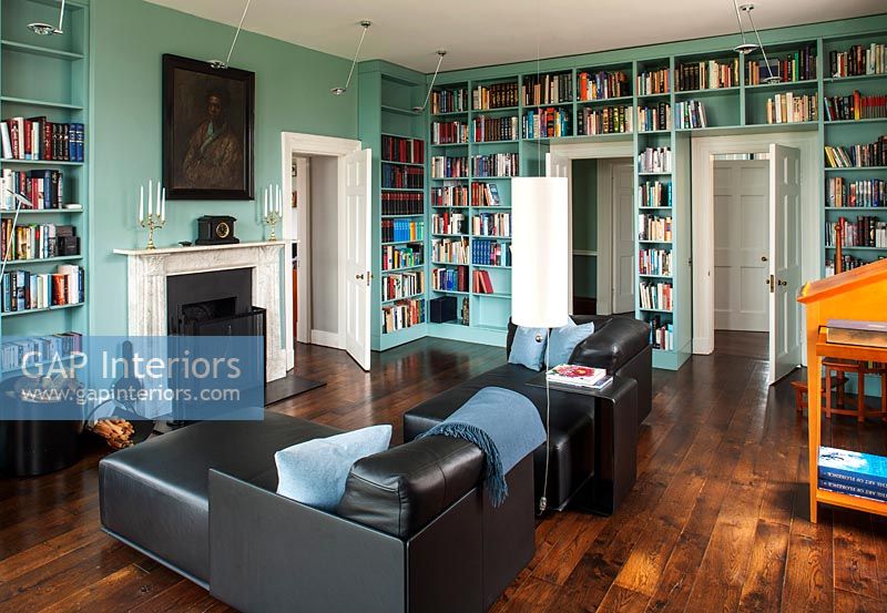 Walls of blue painted bookcases in classic library 