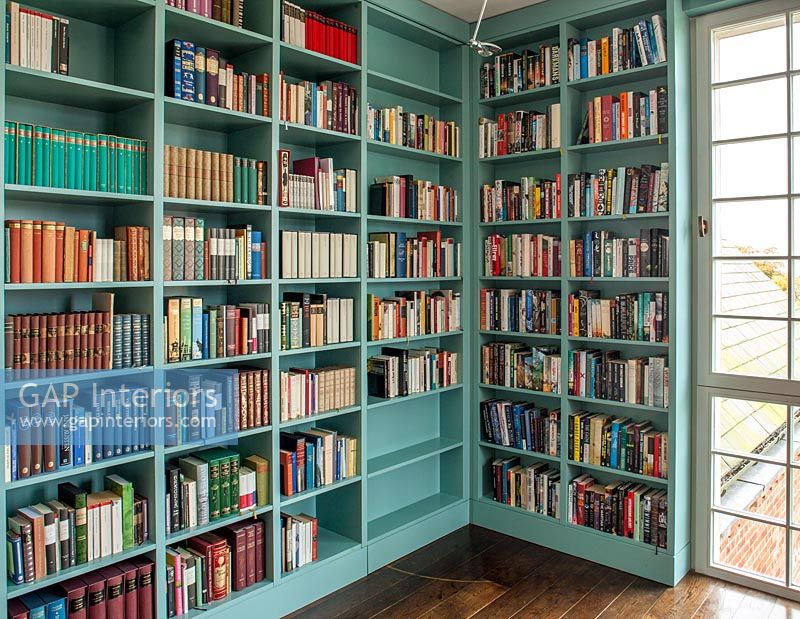 Turquoise painted bookshelves in classic library room 