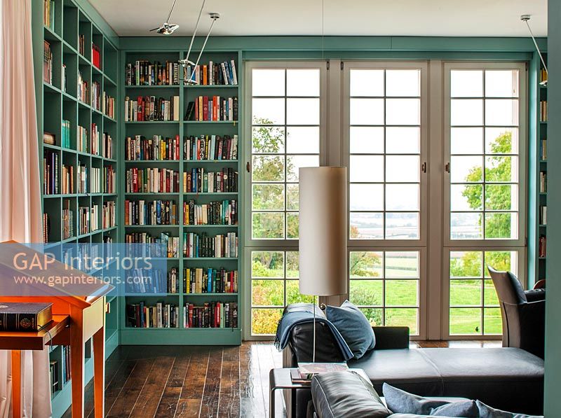Large French windows in classic library with painted bookshelves 