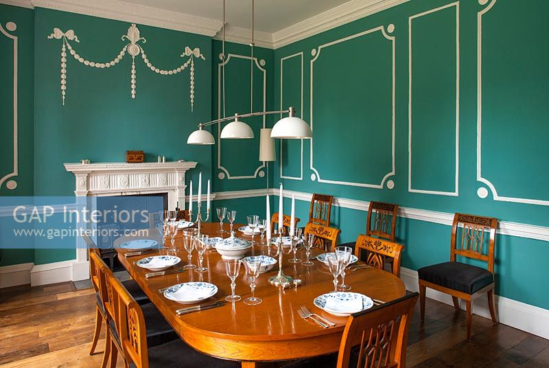 Classic dining room with paneled green and white walls 
