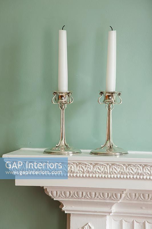 Pair of Art Nouveau silver candlesticks on mantelpiece. 