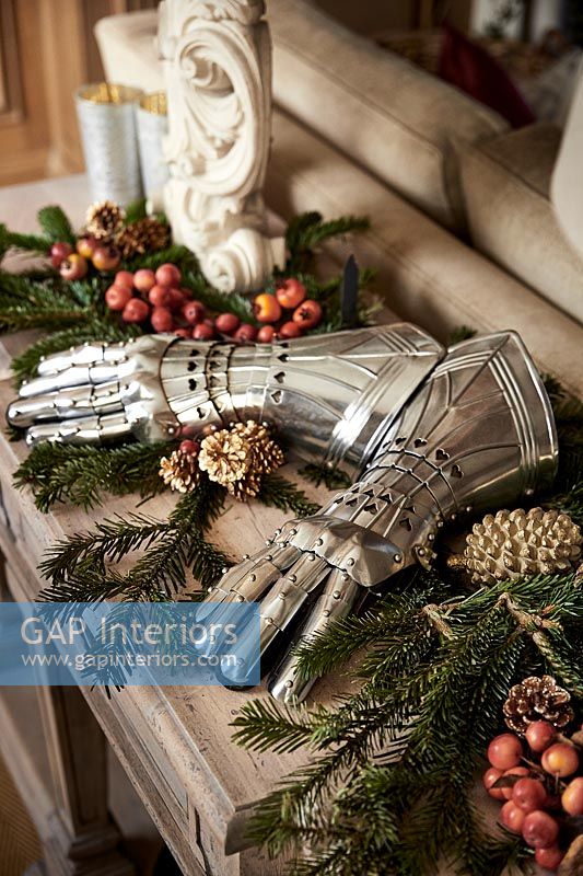 Armoured gloves on table with Christmas decorations 