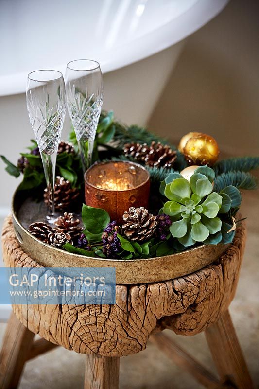 Christmas decorations and glasses on gold tray