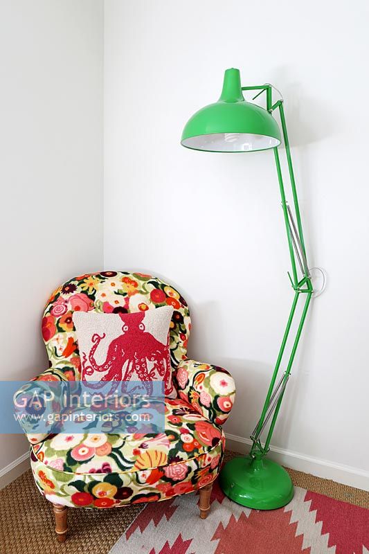 Floral armchair and large green floor lamp 