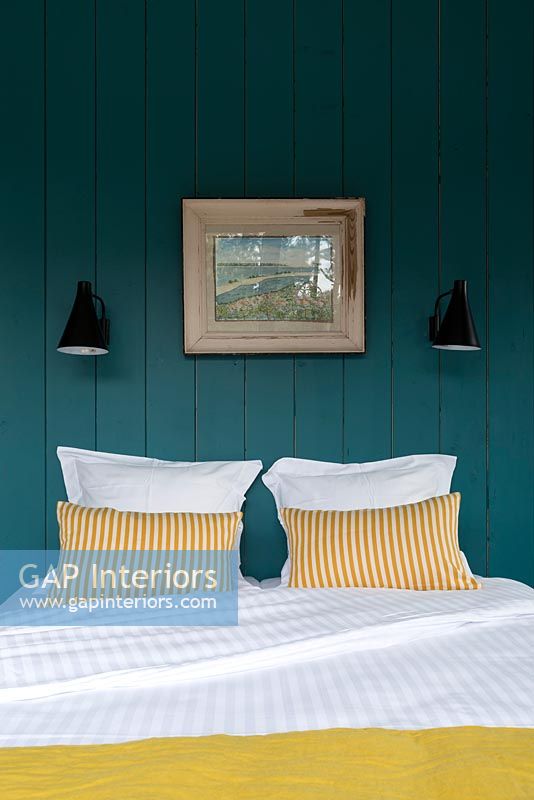 Country bedroom with blue painted wooden walls 