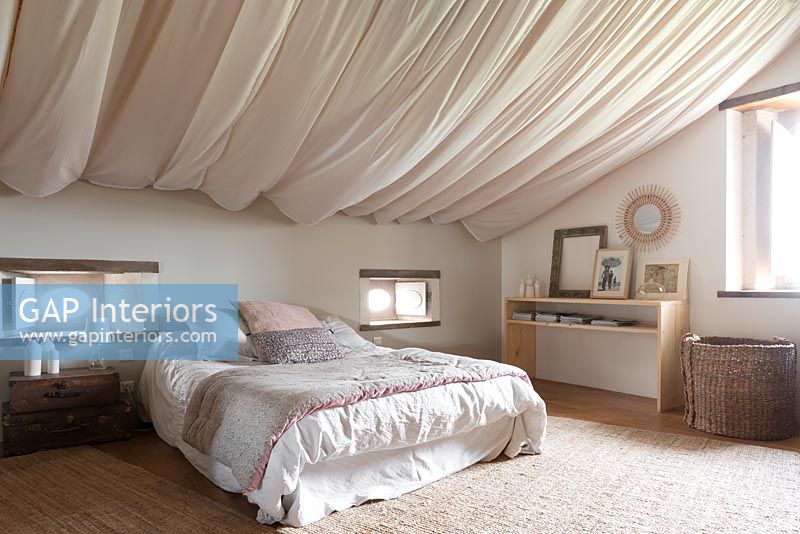 Billowing fabric covers ceiling in country bedroom 