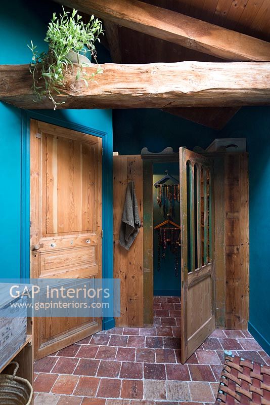 Landing with blue painted walls and exposed wooden beams 