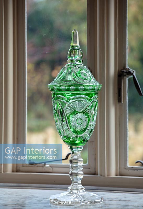 Ornate green vase on windowsill 