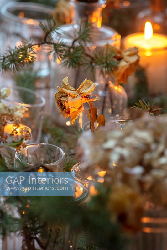Dried flowers in vases and candles on Christmas dining table 