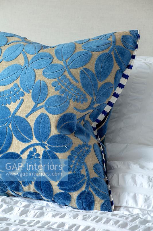Blue velvet cushion on bed 