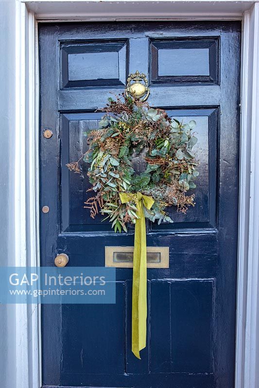 Christmas wreath on classic front door exterior 
