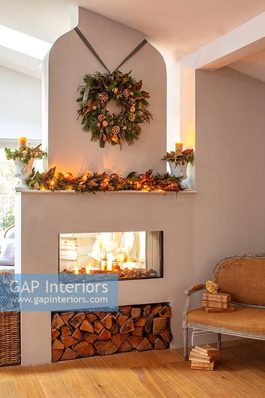 Modern fireplace dressed with Christmas wreath and decorations 