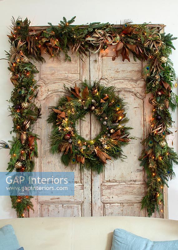 Christmas wreath, garland and lights on stripped wooden internal double doors