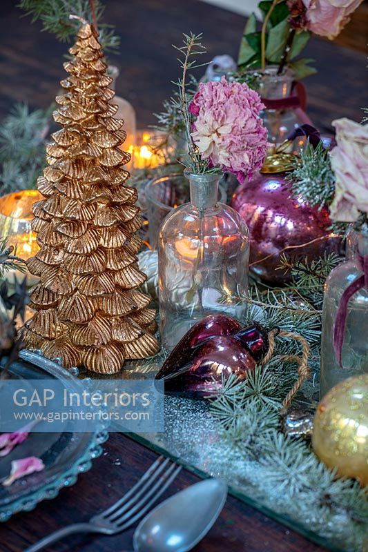 Miniature gold Christmas tree and decorations on dining table 