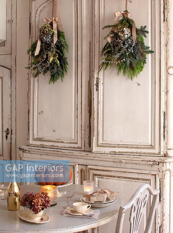Vintage kitchen cupboard doors in kitchen-diner decorated for Christmas 
