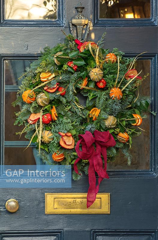 Christmas wreath on dark blue front door 