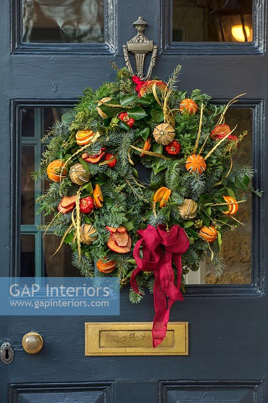 Christmas wreath on dark blue front door 