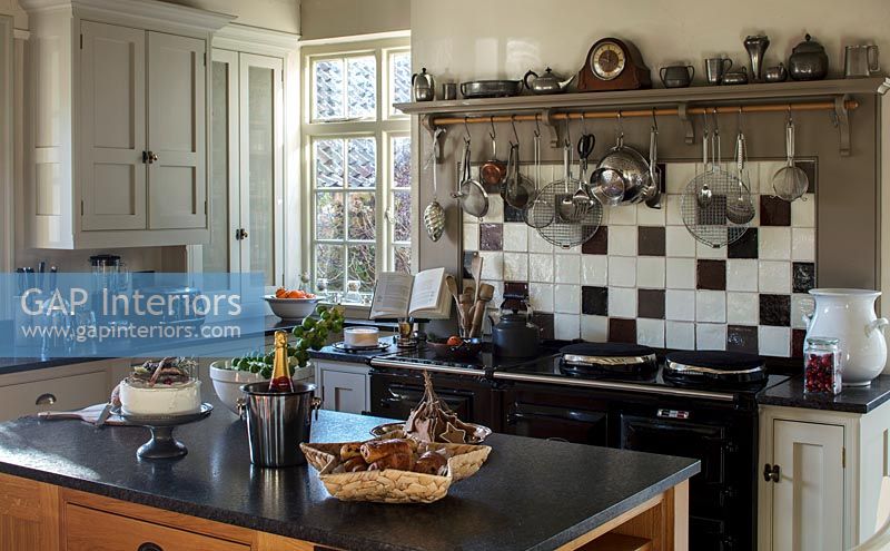 Country kitchen with tiled wall above Aga range cooker 